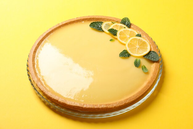 Vassoio di vetro con la crostata al limone su giallo, fine su