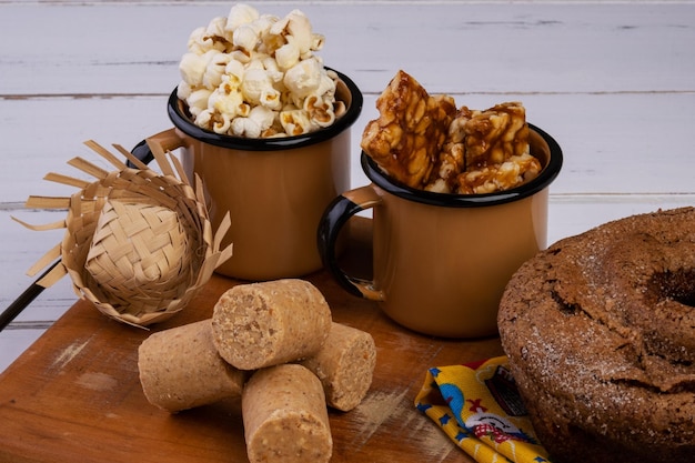 Vassoio in legno con torta popcorn pacoquinha e pe de moleque Festa di giugno