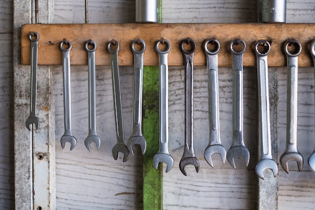 Vecchi attrezzi per bricolage che appendono sulla parete in officina