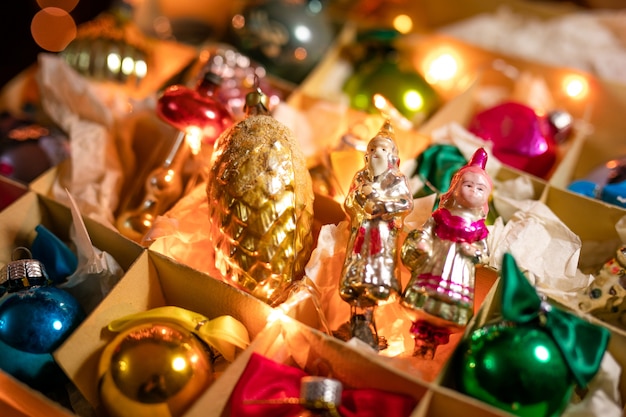 Vecchi giocattoli di vetro, palle e decorazioni per l&#39;albero di Natale sulla scatola di carta