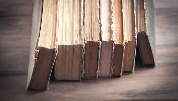 Vecchi libri sulla tavola di legno.