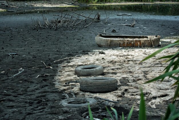 Vecchi pneumatici e immondizia sulla costa Problemi ambientali inquinamento Disastro ecologico