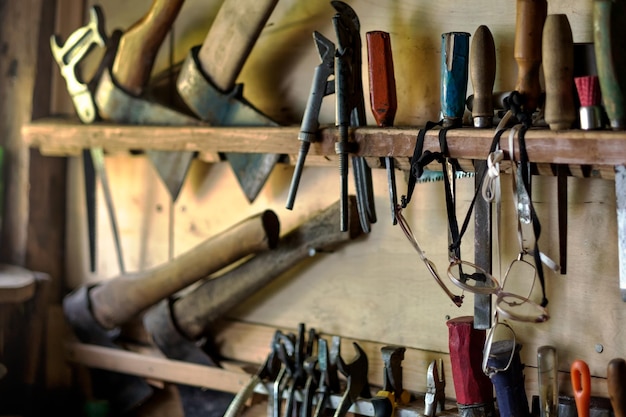 Vecchi strumenti per lavori di falegnameria appesi su rack
