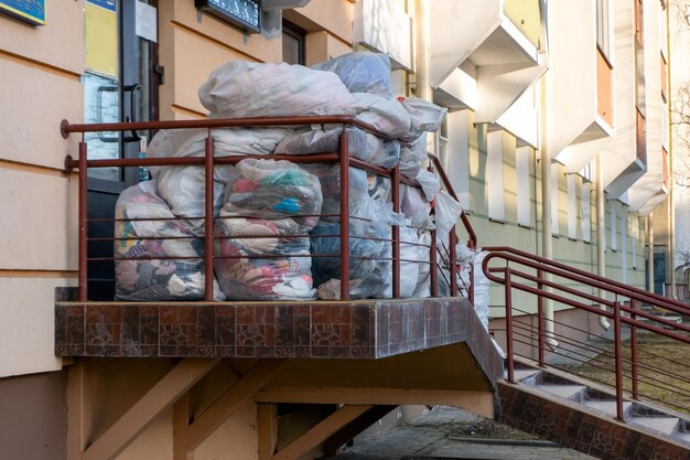 Vecchi vestiti usati in sacchetti di plastica Nuovo arrivo della merce nel negozio dell'usato Aiuto umanitario per i bambini colpiti dalla guerra in Ucraina