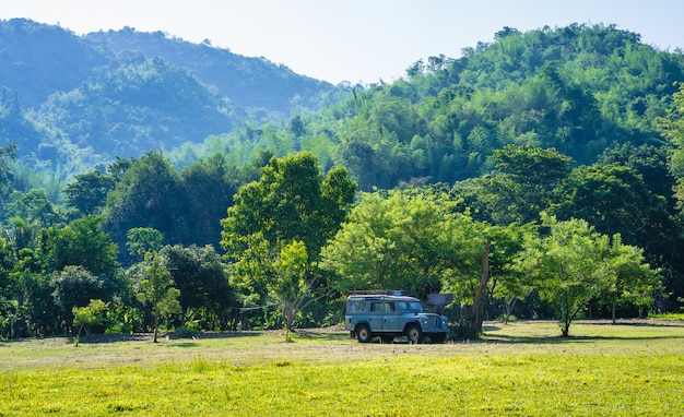 Vecchia automobile nel campo con la priorità bassa della montagna