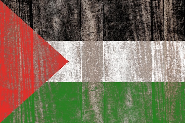 Vecchia bandiera danneggiata della Palestina dipinta su uno sfondo di legno invecchiato