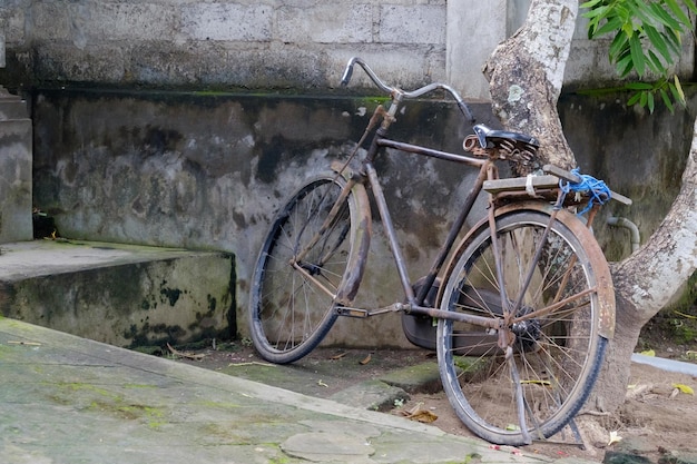 Vecchia bicicletta parcheggiata vicino al muro di pietra in Asia