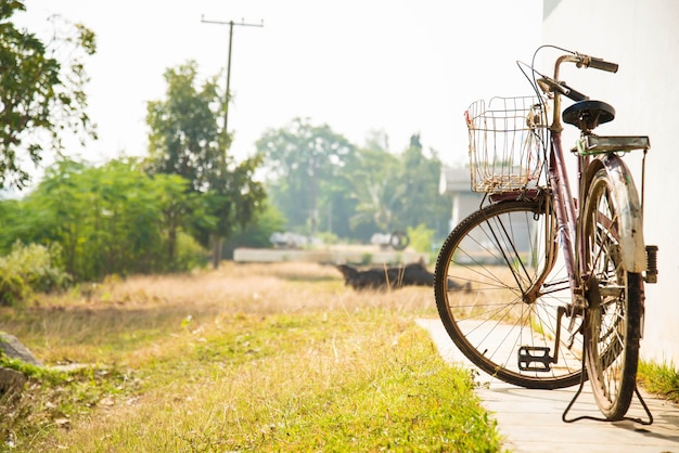 Vecchia bicicletta sul lato della casa per lo sfondo.