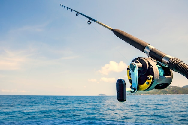 vecchia canna da pesca e acqua di mare blu