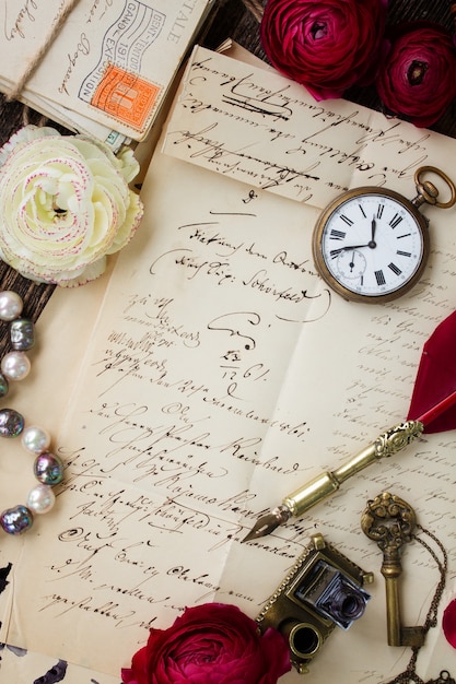 Vecchia carta con macchie di inchiostro e vecchia lettera con orologio antico e penna piuma