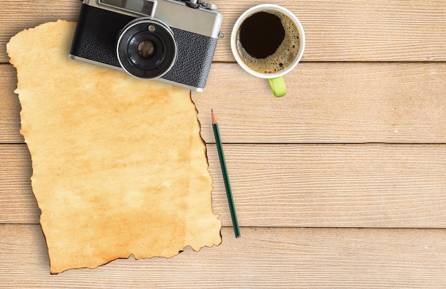 Vecchia carta e macchina fotografica vintage con tazza di caffè sul tavolo di legno