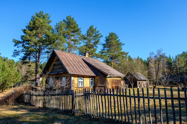 Vecchia casa di campagna in legno nel villaggio dell'entroterra russo all'alba nella pineta Turismo ecologico e ricreativo