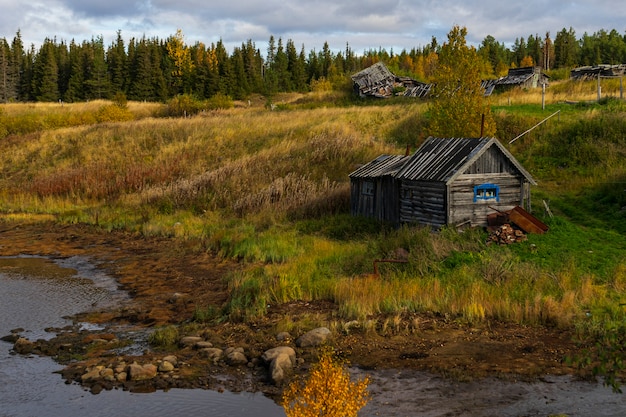 Vecchia casa in legno sul fiume, lontano dalla città, regione di Murmansk in autunno, paesaggio