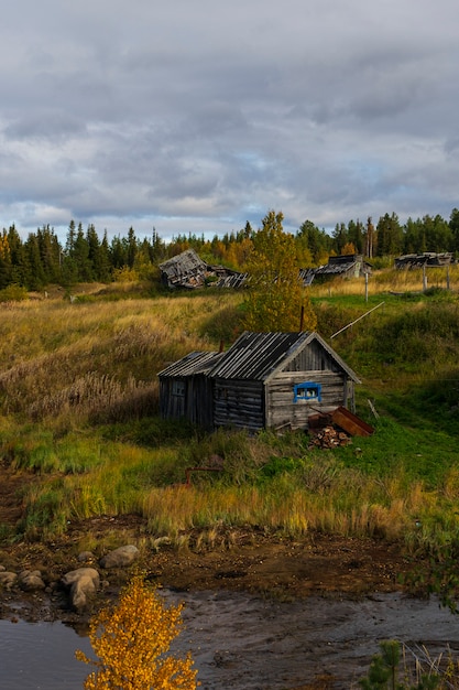 Vecchia casa in legno sul fiume, lontano dalla città, regione di Murmansk in autunno, paesaggio