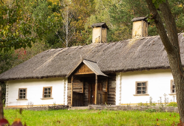 Vecchia casa in legno sullo sfondo degli alberi autunnali