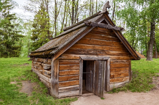 Vecchia casa ucraina con un tetto in legno e un'insolita porta d'ingresso