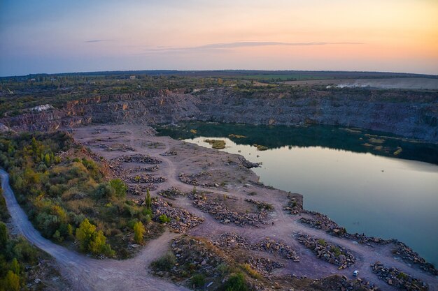 Vecchia cava di pietra allagata con grandi pietre la sera calda luce brillante ricoperta di piccole piante secche nella pittoresca Ucraina