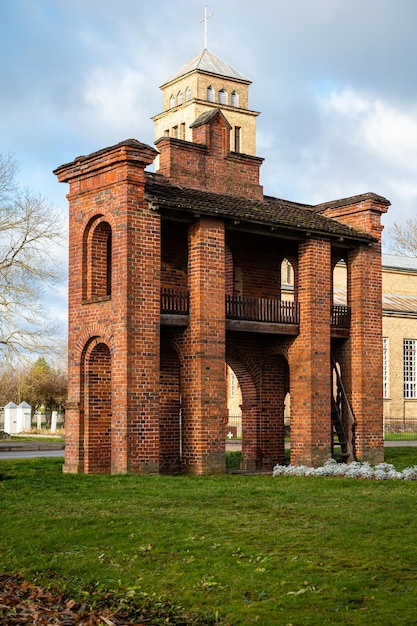 Vecchia chiesa cattolica e cancelli in mattoni rossi nella città di Akniste Lettonia