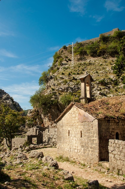 Vecchia chiesa della parete della fortezza alta nelle montagne nel punto di riferimento storico antico di Cattaro del montenegro