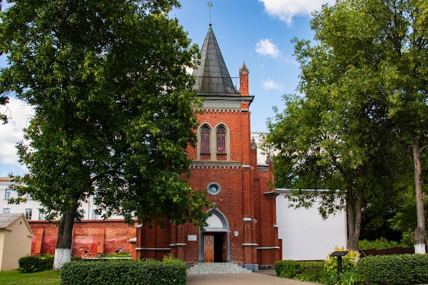 Vecchia chiesa in mattoni rossi tra alberi verdi a Polotsk