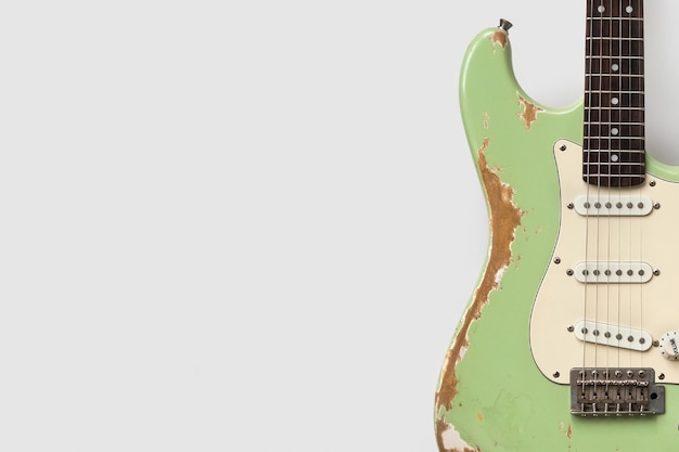 Vecchia chitarra verde su sfondo bianco
