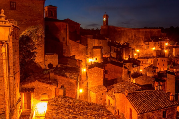 Vecchia città italiana di Sorano di notte. I lampioni illuminano i tetti delle vecchie case