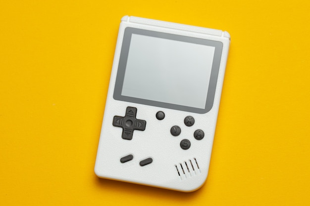 Vecchia console di gioco. Il gamepad è bianco su sfondo giallo.