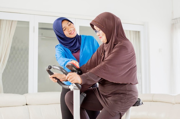 Vecchia donna musulmana che fa allenamento sulla cyclette