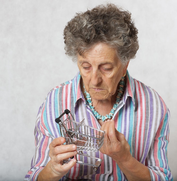 Vecchia donna tra i 70 e gli 80 anni con un mini carrello.