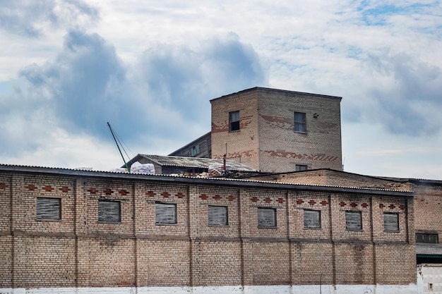 Vecchia fabbrica di mattoni e cielo con nuvole blu