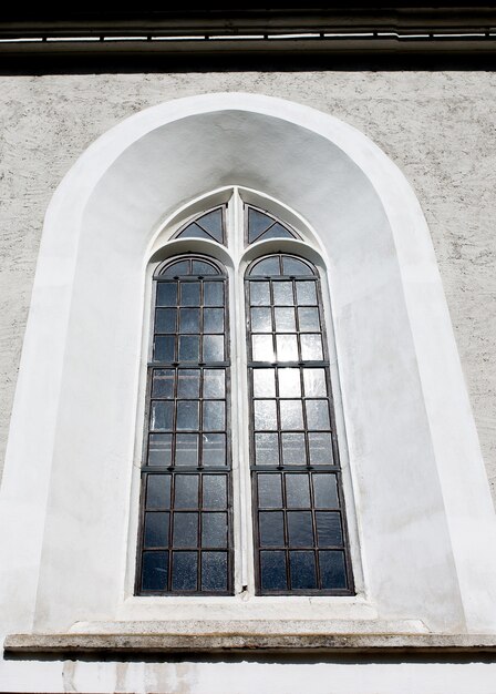 Vecchia finestra gotica sulla facciata della chiesa cattolica. Immagine scattata in una giornata di sole