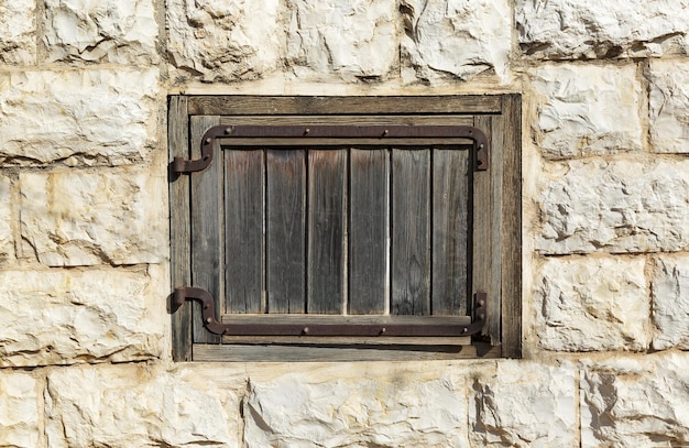 Vecchia finestra in legno su un muro di pietra