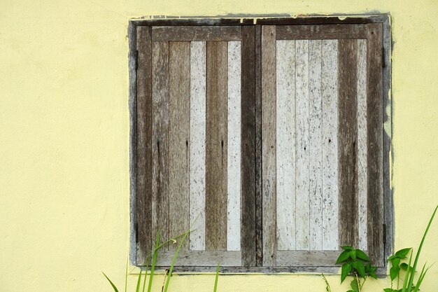 Vecchia finestra in legno sul muro di cemento