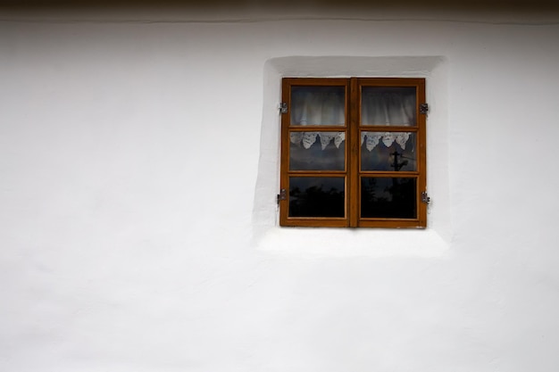 Vecchia finestra sullo sfondo di un muro bianco. Cornice orizzontale.