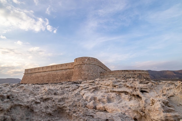 Vecchia fortezza abbandonata di fronte al mare su rocce bianche a cabo de gata spagna