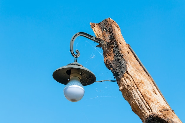 Vecchia lampada su palo in legno su bluesky