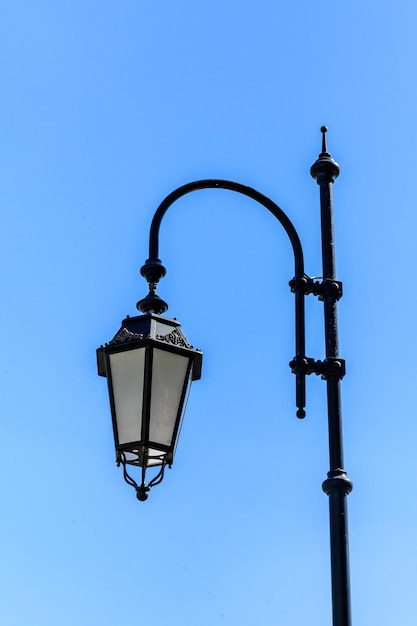 Vecchia lanterna su un palo di metallo contro il cielo blu