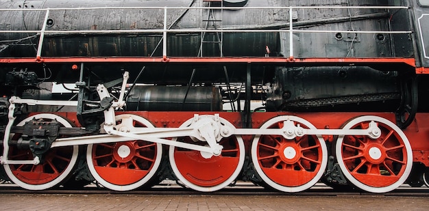 Vecchia locomotiva a vapore su grandi ruote rosse Le ruote del treno si chiudono su Ferrovia