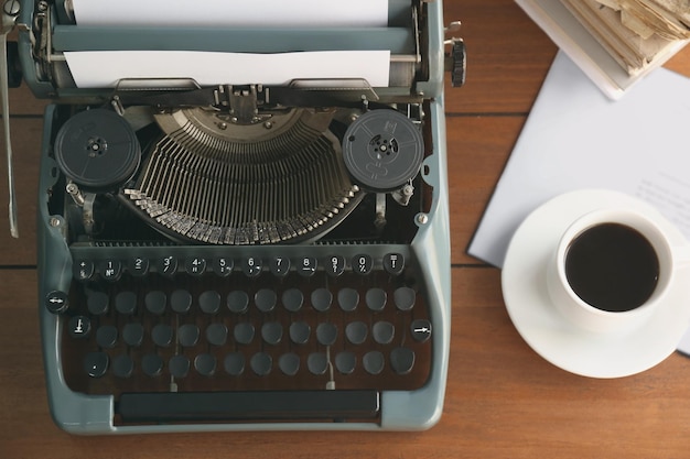 Vecchia macchina da scrivere e tazza di caffè sul tavolo