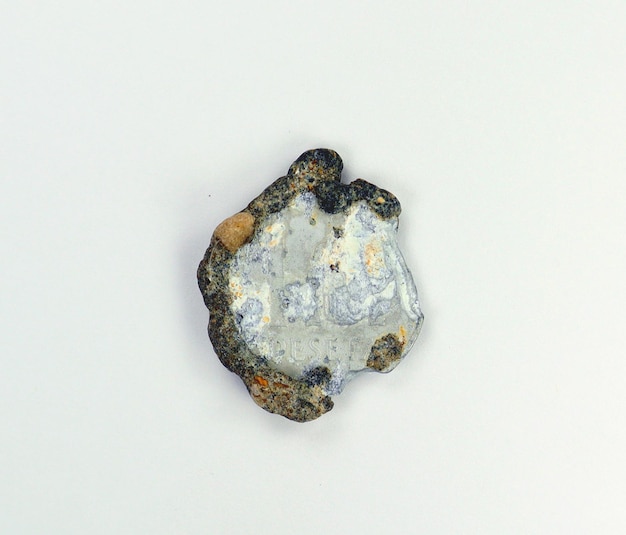 Vecchia moneta peseta dal fondo del mare, ricoperta di escrescenze, corrosione del metallo, deformazione