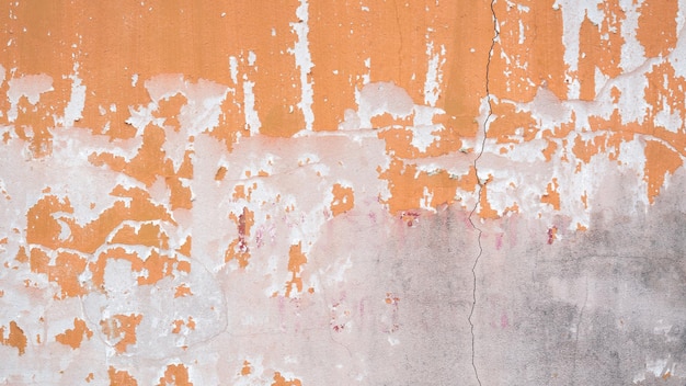 Vecchia parete di cemento sbucciata sfondo di consistenza esterna con sbucciatura di vernice di bassa qualità parete rotta