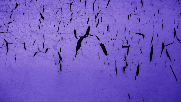 Vecchia parete di cemento sbucciata sfondo di consistenza esterna con vernice viola sbucciato parete rotta di bassa qualità
