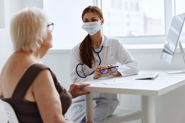 Vecchia paziente donna comunica con l'ufficio medico medico foto di alta qualità