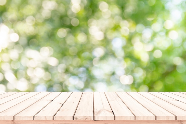 Vecchia plancia di legno con il fondo vago verde naturale astratto del bokeh per l'esposizione del prodotto