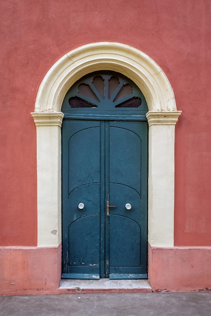 Vecchia porta d'ingresso in legno sulla facciata dell'antico edificio barocco nell'architettura tradizionale di Catania Sicilia, Italia.