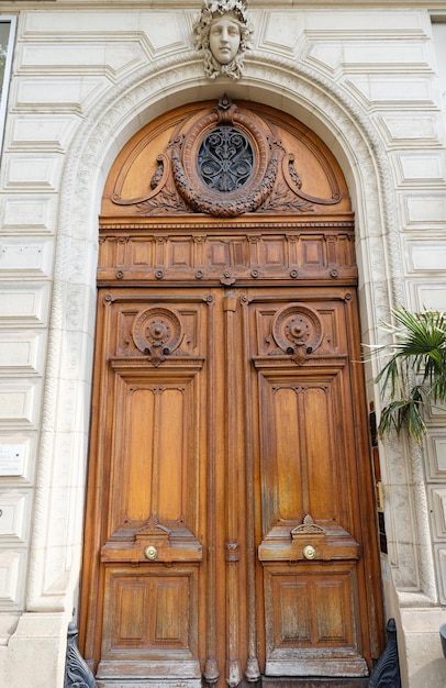 Vecchia porta decorata nel tipico edificio di appartamenti vecchio di Parigi