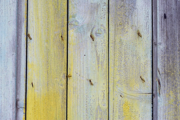 Vecchia porta di legno con sfondo vintage shabby ravvicinato Sfondo estivo blu e giallo