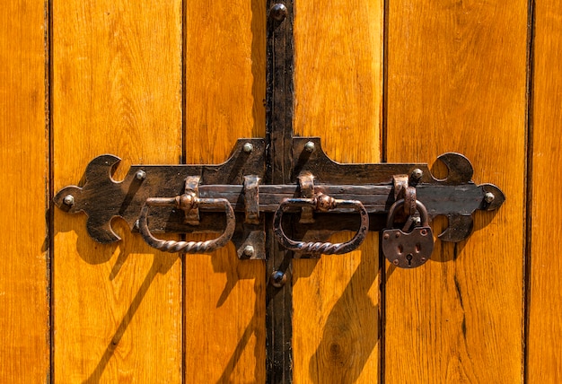 Vecchia porta di legno della serratura del ferro battuto