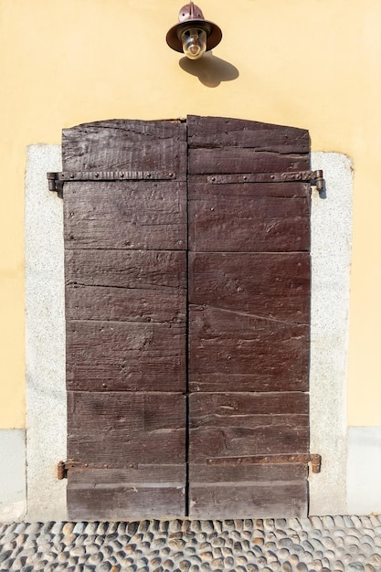 Vecchia porta di legno di colore marrone e lama da parete sopra la porta