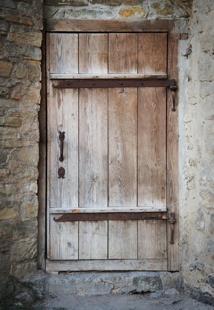 Vecchia porta di legno in un muro di pietra